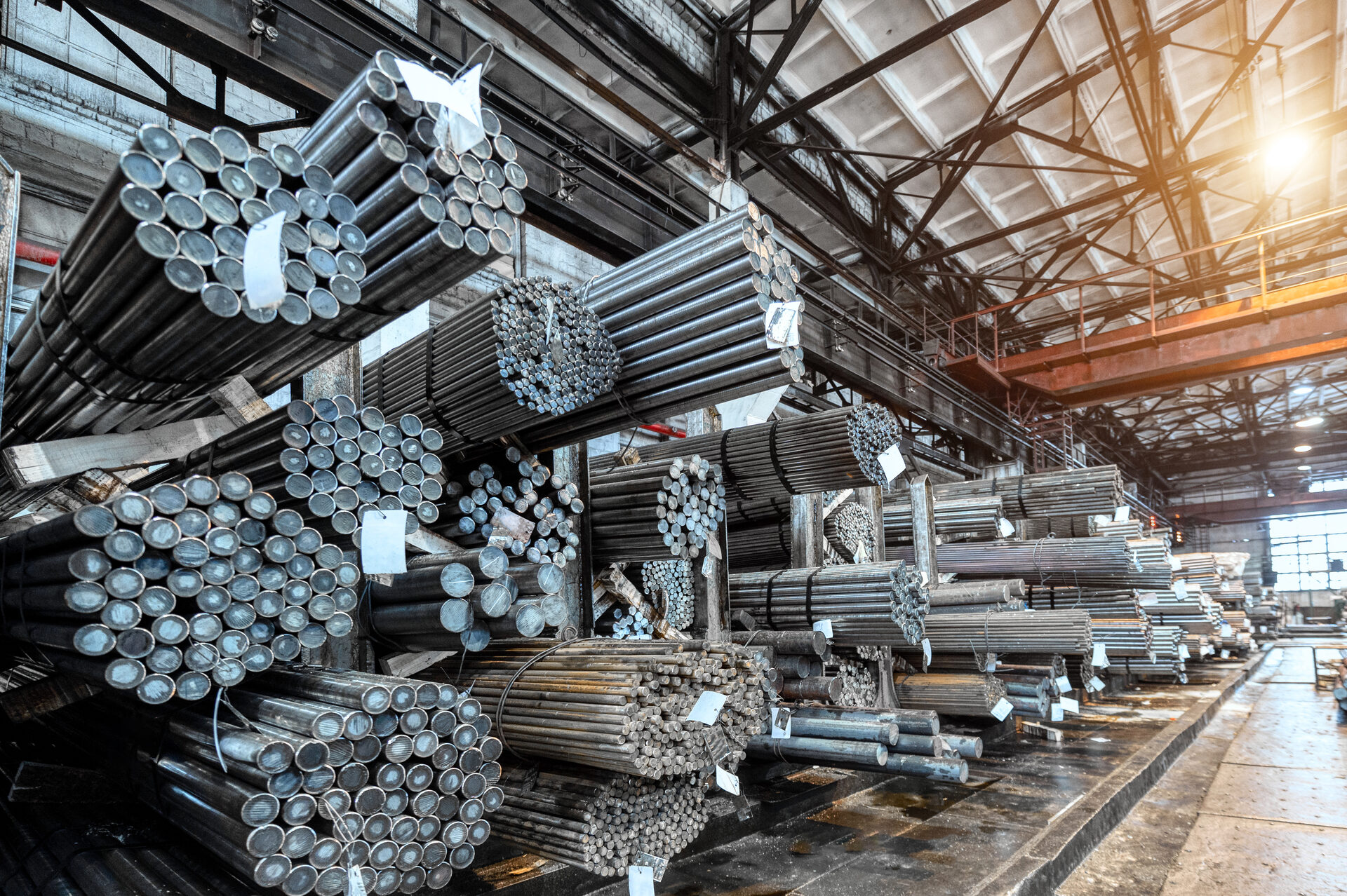 Rolled metal warehouse with packs of metal bars on shelves