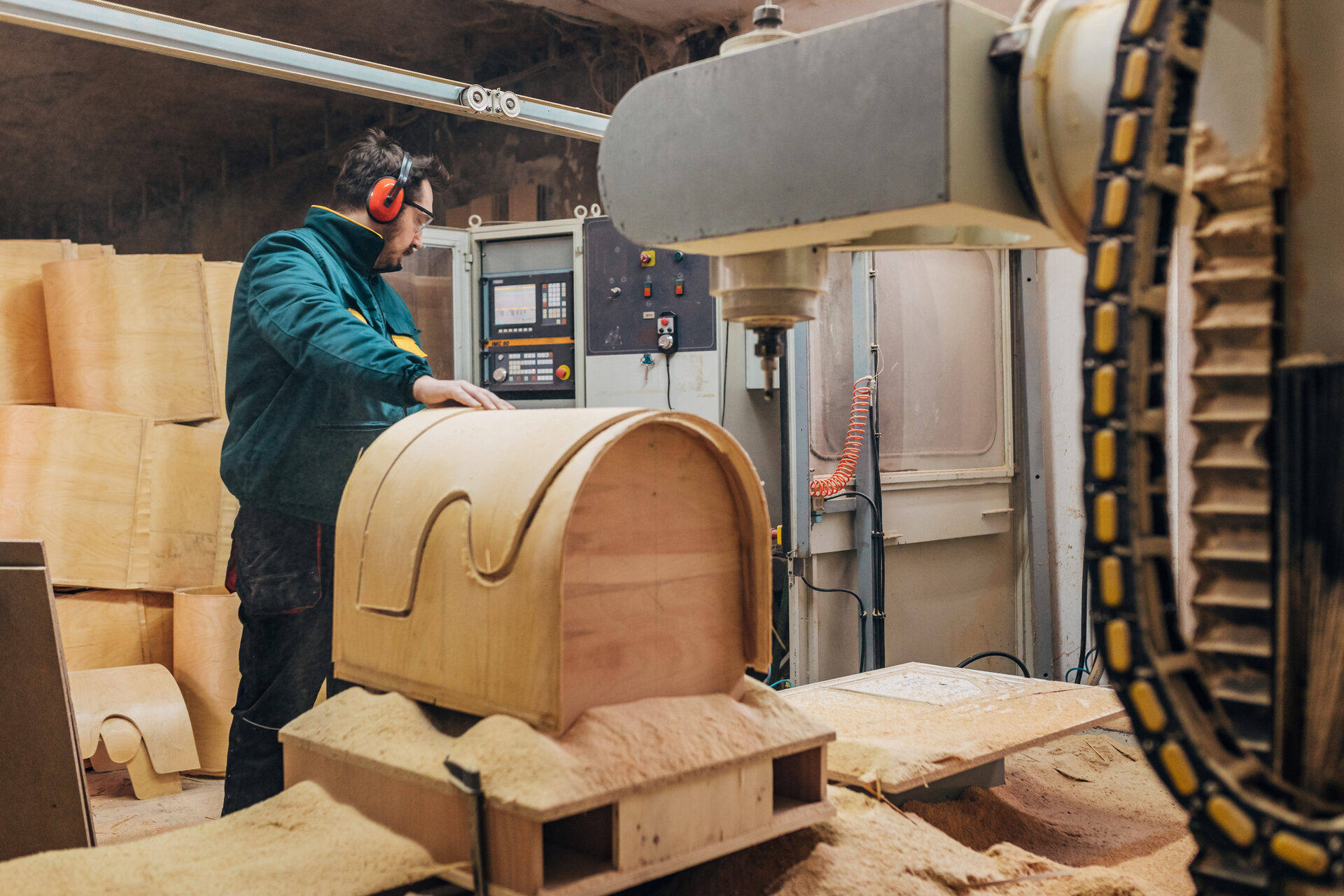Carpenter operating a CNC machine while wearing PPE